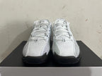 Front view of white Nike basketball shoes with lace-up closure and black outsole accents.