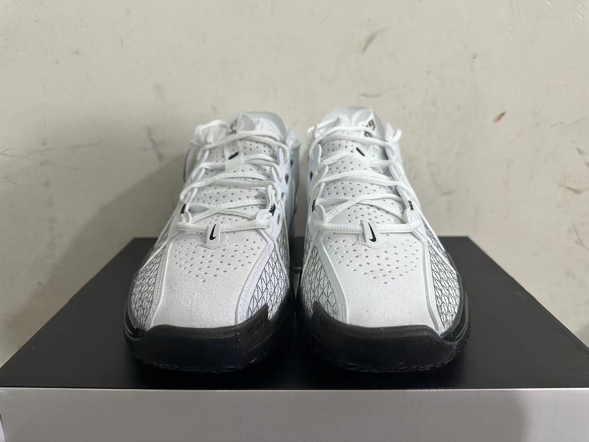 Front view of white Nike basketball shoes with lace-up closure and black outsole accents.