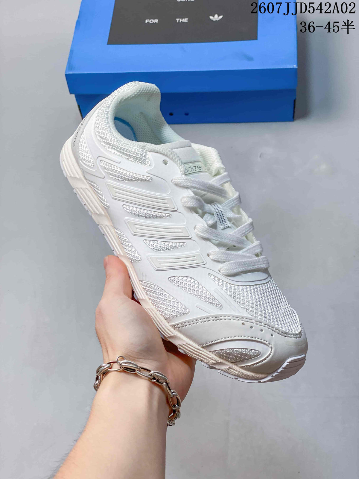 Angled side view of the white sneaker showing its layered design and textured upper.