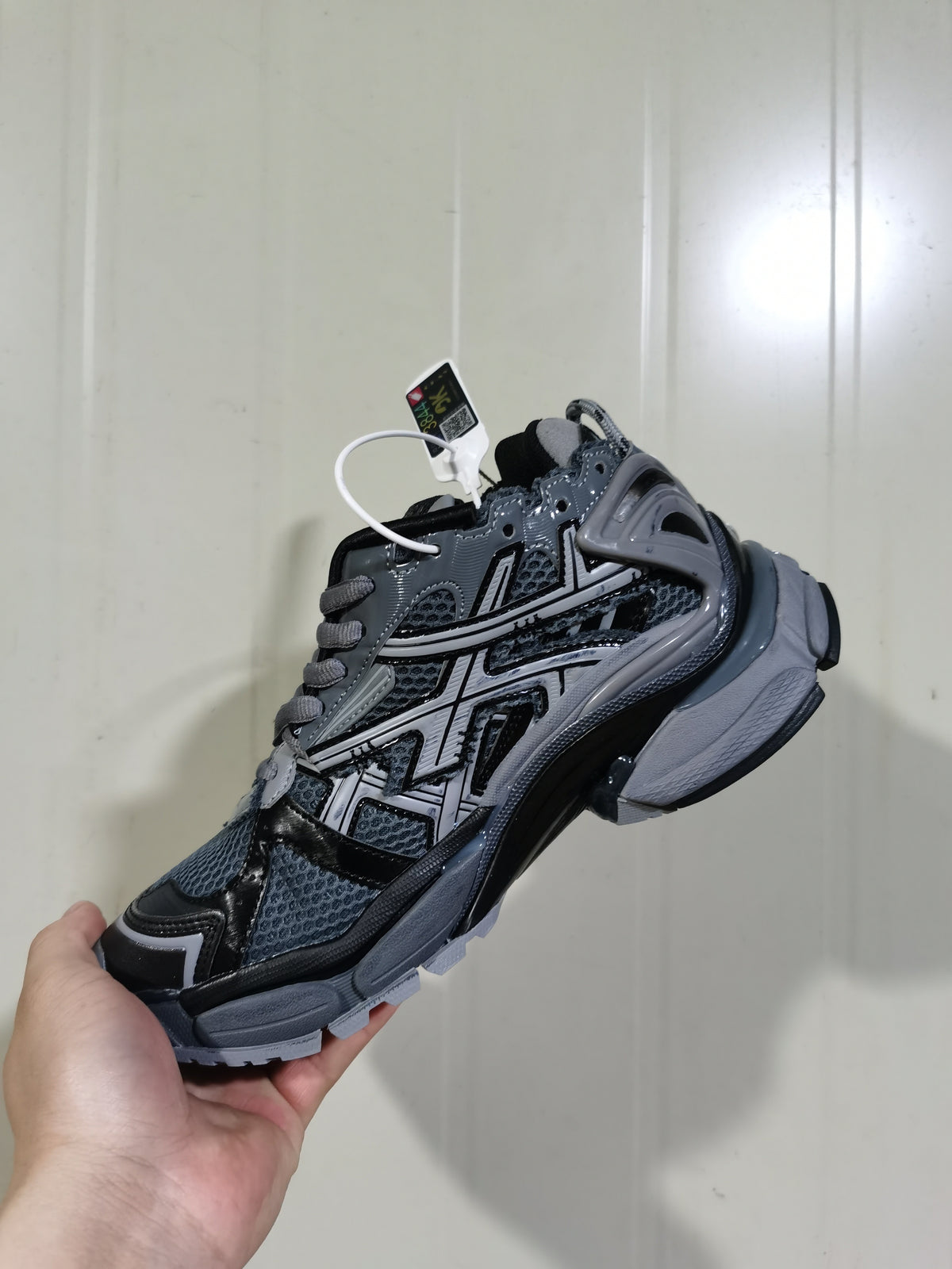 Side and outsole view of the dark grey and black Balenciaga Runner sneaker, showing the layered construction, heel structure, and textured tread.