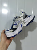 Angled view of white, gray, blue, and black Balenciaga Cargo sneakers with a layered upper and chunky sole.