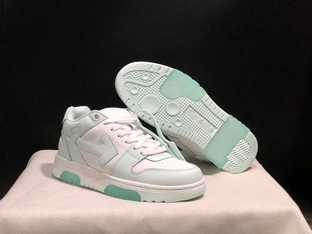 Angled view of the sneakers with one shoe lifted to reveal the patterned outsole and pale mint rubber sections.