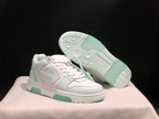 Angled view of the sneakers with one shoe lifted to reveal the patterned outsole and pale mint rubber sections.