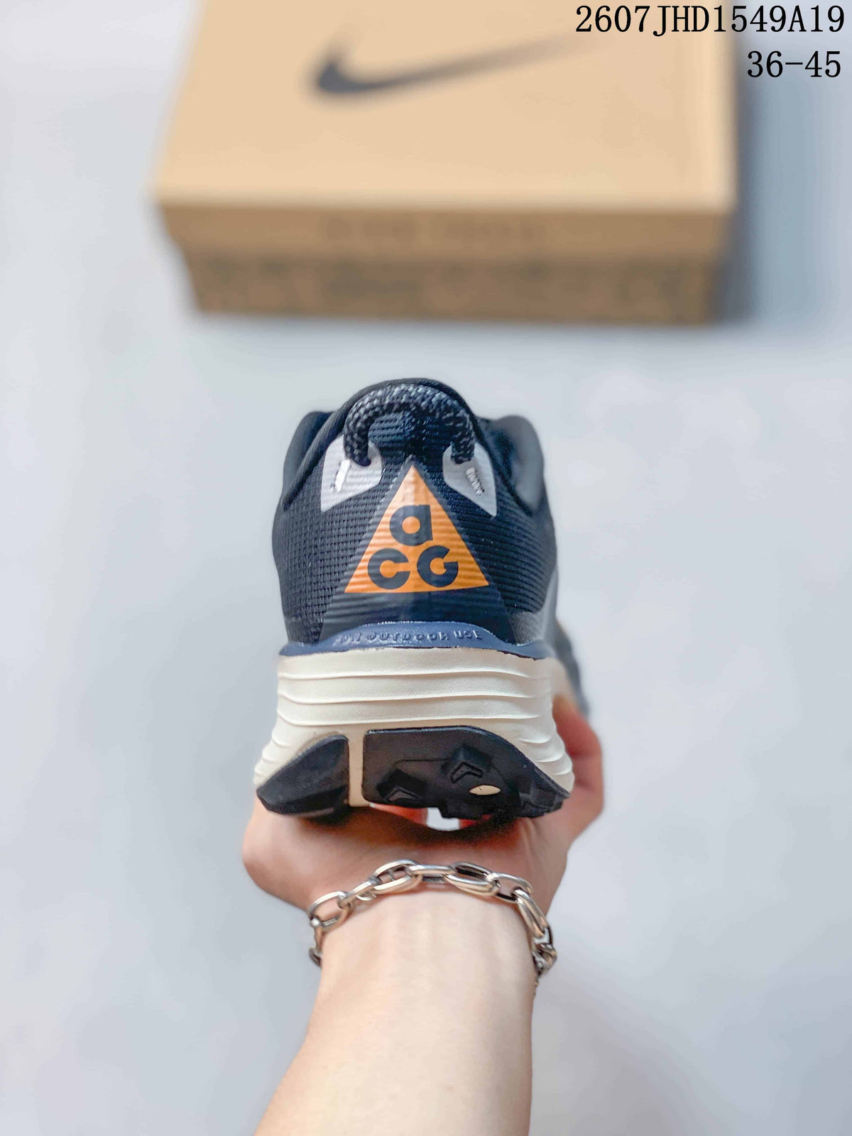 Rear view showing the padded heel, orange ACG-style tongue detail, and layered sole.