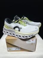 White and lime On Cloudmonster 2 shoes displayed on their box; the box label shows the photographed sample size.