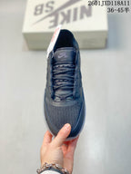Top view of a dark gray Nike SB shoe showing the knit-style toe area, laces, tongue, and padded collar.