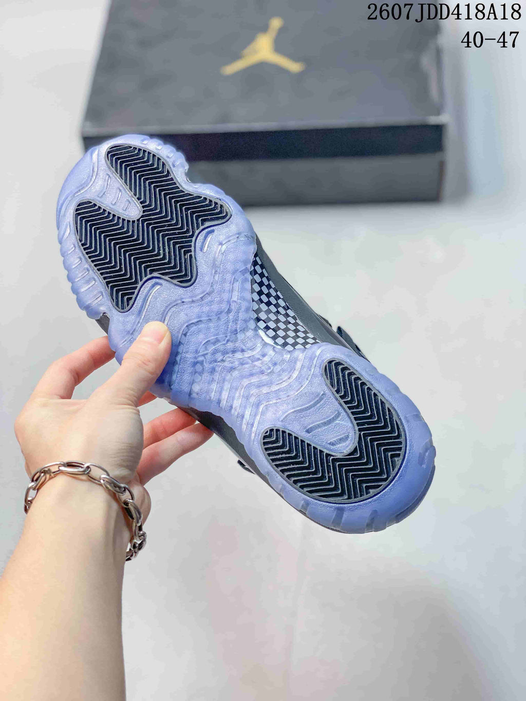 Underside view of a sneaker showing a translucent icy outsole with black patterned traction sections; the source-marked range 40–47 is visible.