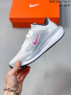Side profile of the white low-top running shoe with pink branding and a raised white midsole.