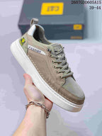 Close-up side view of a taupe CAT sneaker showing the stitched upper, lace system, padded collar and white outsole.