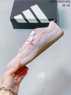 Side profile of a pink Adidas sneaker with mesh-look panels and crossed straps