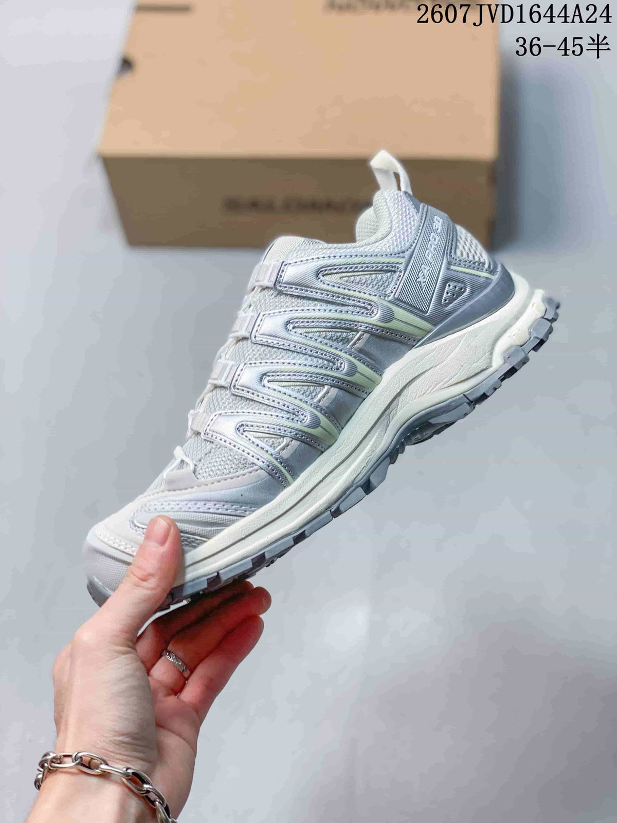 Side view of the light gray Salomon sneaker showing mesh panels, layered overlays, midsole and lugged outsole.