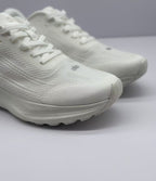 Close-up of the white sneaker toe box, laces, textured upper, and layered midsole.