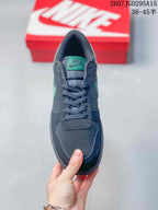 Top view of the black sneaker showing the mint-green tongue label, dark laces, padded tongue, and perforated toe box.