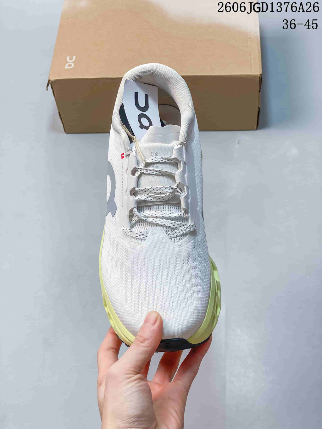 Top view of a white On running shoe showing the lace system, padded collar and contrasting lime sole edge.