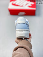 Rear view of the light blue and white sneaker showing the padded heel, Nike branding and raised sole.