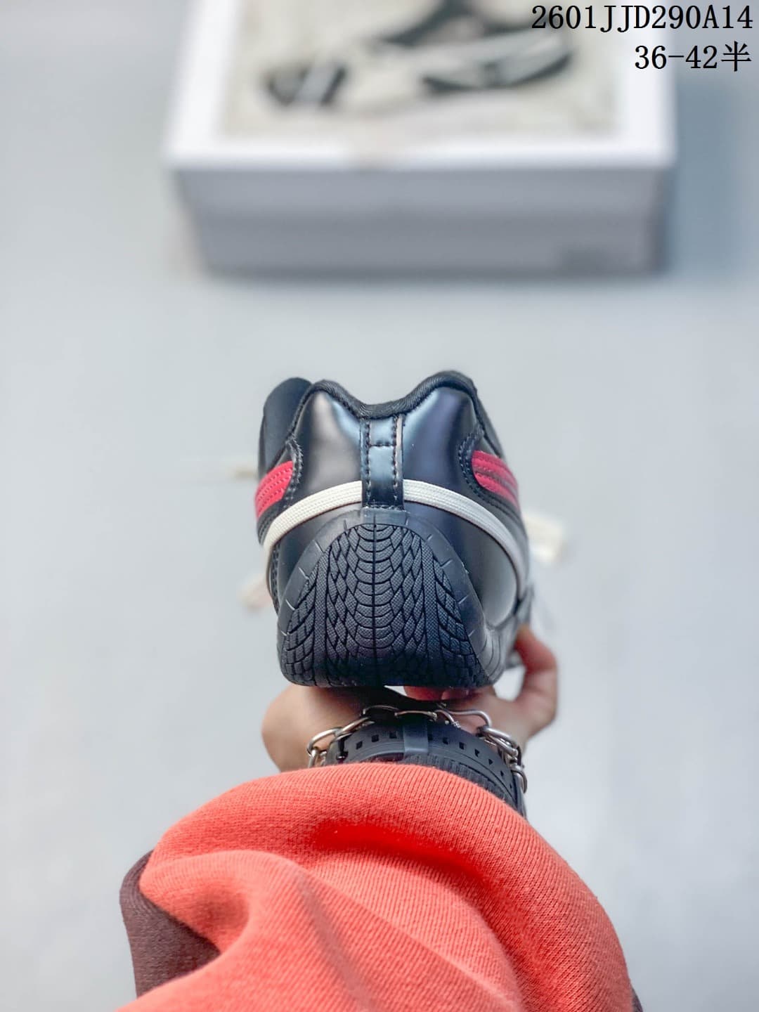 Rear view showing the black heel, red accents, contrasting lace detail, and textured outsole.