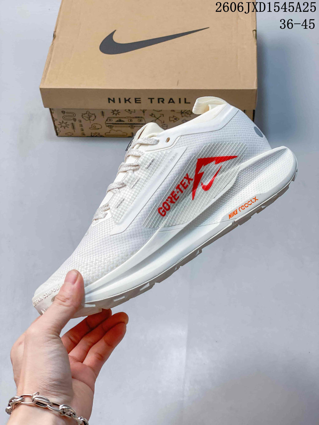 Side view of the white shoe with red GTX branding and trail outsole