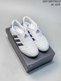 White and navy adidas low-top sneakers displayed on a black shoebox, with the size range marking visible at the upper right.