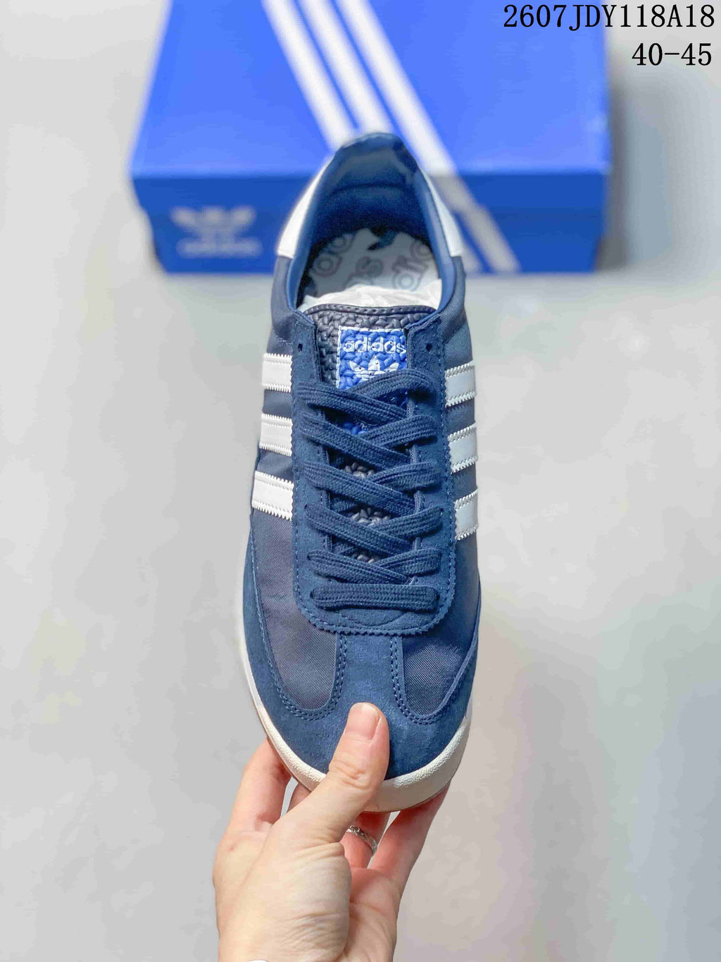 Top view showing the navy lace-up upper, white side stripes, and adidas tongue label.