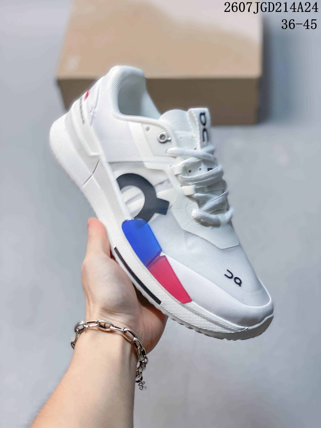 Angled lateral view of the white shoe showing blue and pink side accents, On branding, and the raised sole.