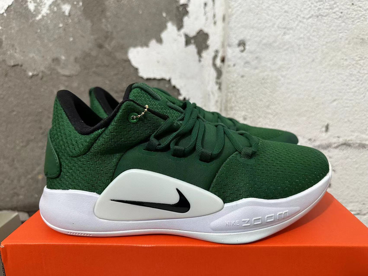 Side view of a green Nike shoe showing the black swoosh and Zoom lettering