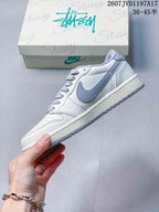 Side profile showing the white upper, grey Swoosh overlay, patterned laces, and low-top silhouette.