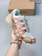 Angled side view showing the Salomon branding, mesh-style upper, bronze overlays and textured outsole.