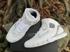 Pair of white high-top sneakers showing the strap, laces, and side detailing