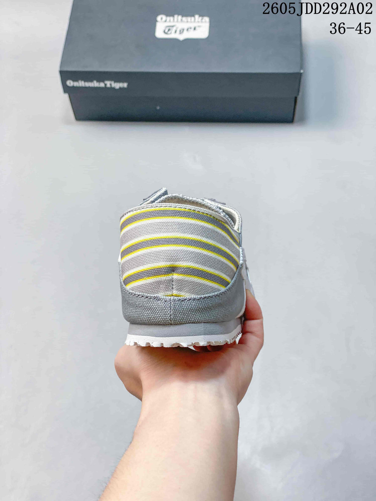 Rear view showing the gray heel and striped heel panels with yellow accents.