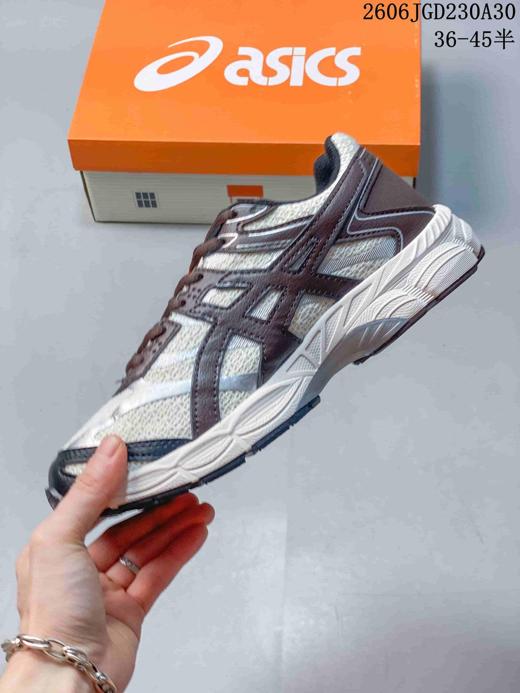 Side profile of an ASICS GEL-CUMULUS 16 shoe with light panels, dark overlays and orange accents.