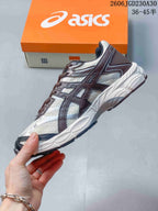 Side profile of an ASICS GEL-CUMULUS 16 shoe with light panels, dark overlays and orange accents.