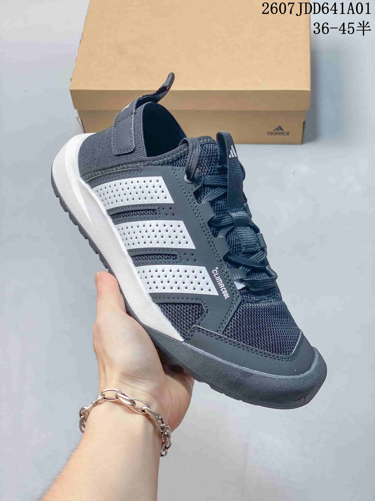 Close side view of a gray outdoor sneaker with lace-up front and textured toe bumper.