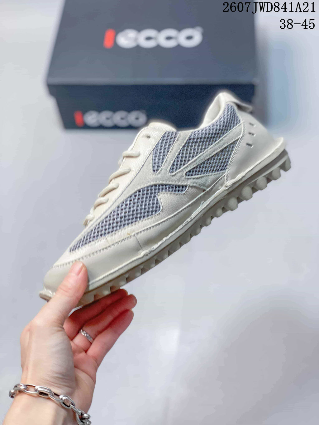 Side view highlighting the white and gray mesh panels, lace-up construction, and raised outsole tread.