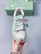 Top view of the sneaker showing white laces, a perforated white toe panel, mint green overlays, and a hanging character charm.