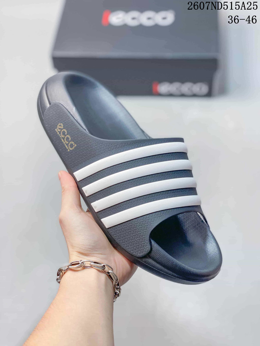 Close-up view of a navy ECCO slide sandal with multiple white stripes across the upper and a textured footbed.