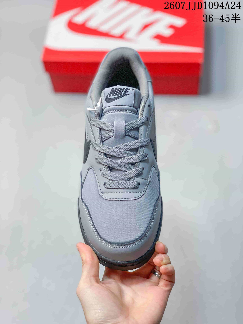 Top view of the gray lace-up sneaker showing the tongue label, laces, toe panel, and padded collar.