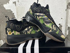 Pair of camouflage BAPE STA sneakers displayed in overlapping side views.