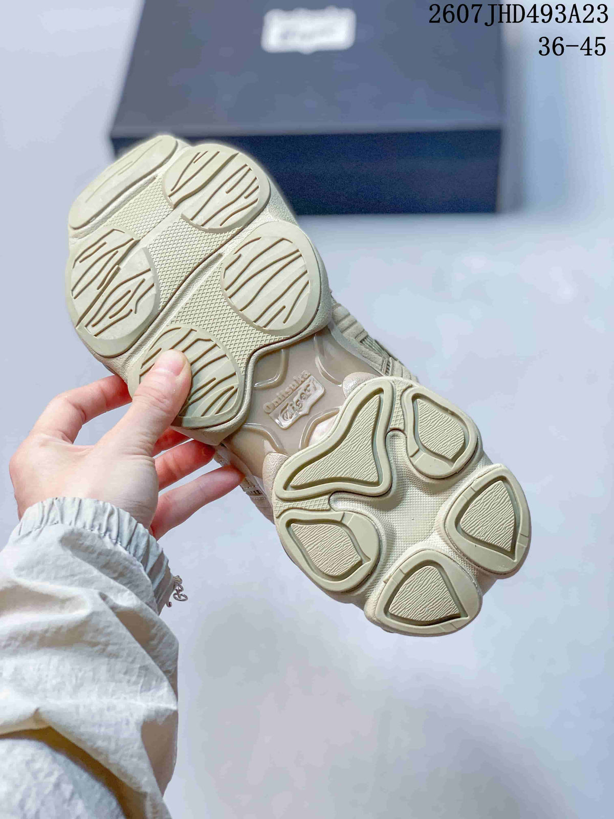 Close view of the patterned outsole on a beige and cream Onitsuka Tiger TIGRUN sneaker.