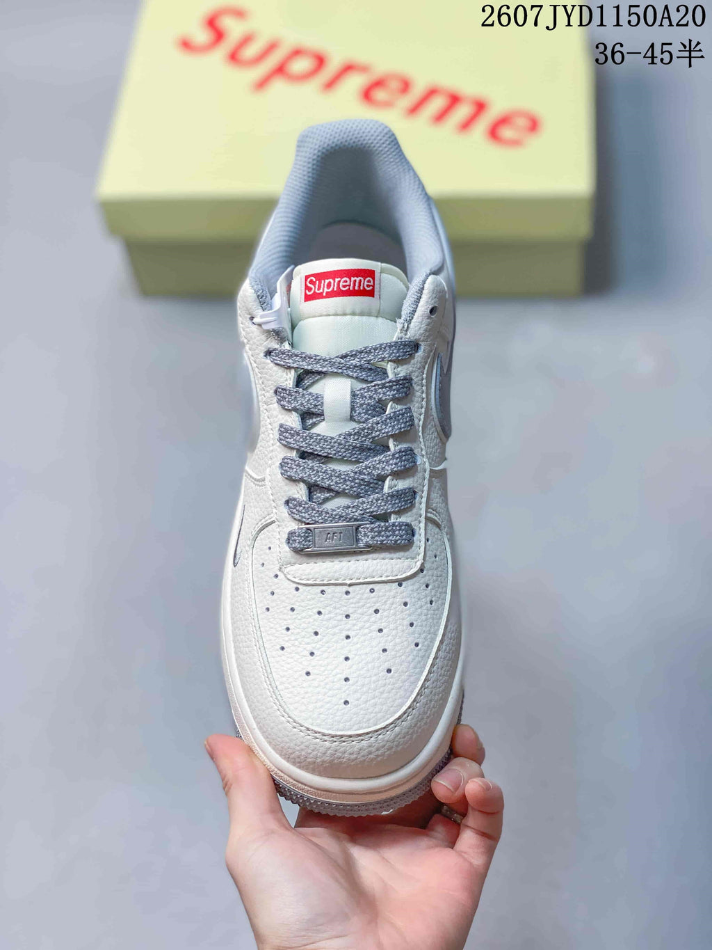 Top view of the sneaker showing the perforated white toe box, grey laces, tongue label, and grey collar lining.