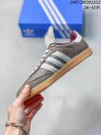 Side view highlighting the white three stripes, gray upper, and low-top profile.
