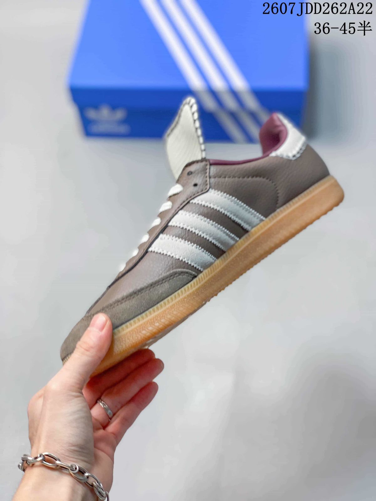 Side view highlighting the white three stripes, gray upper, and low-top profile.