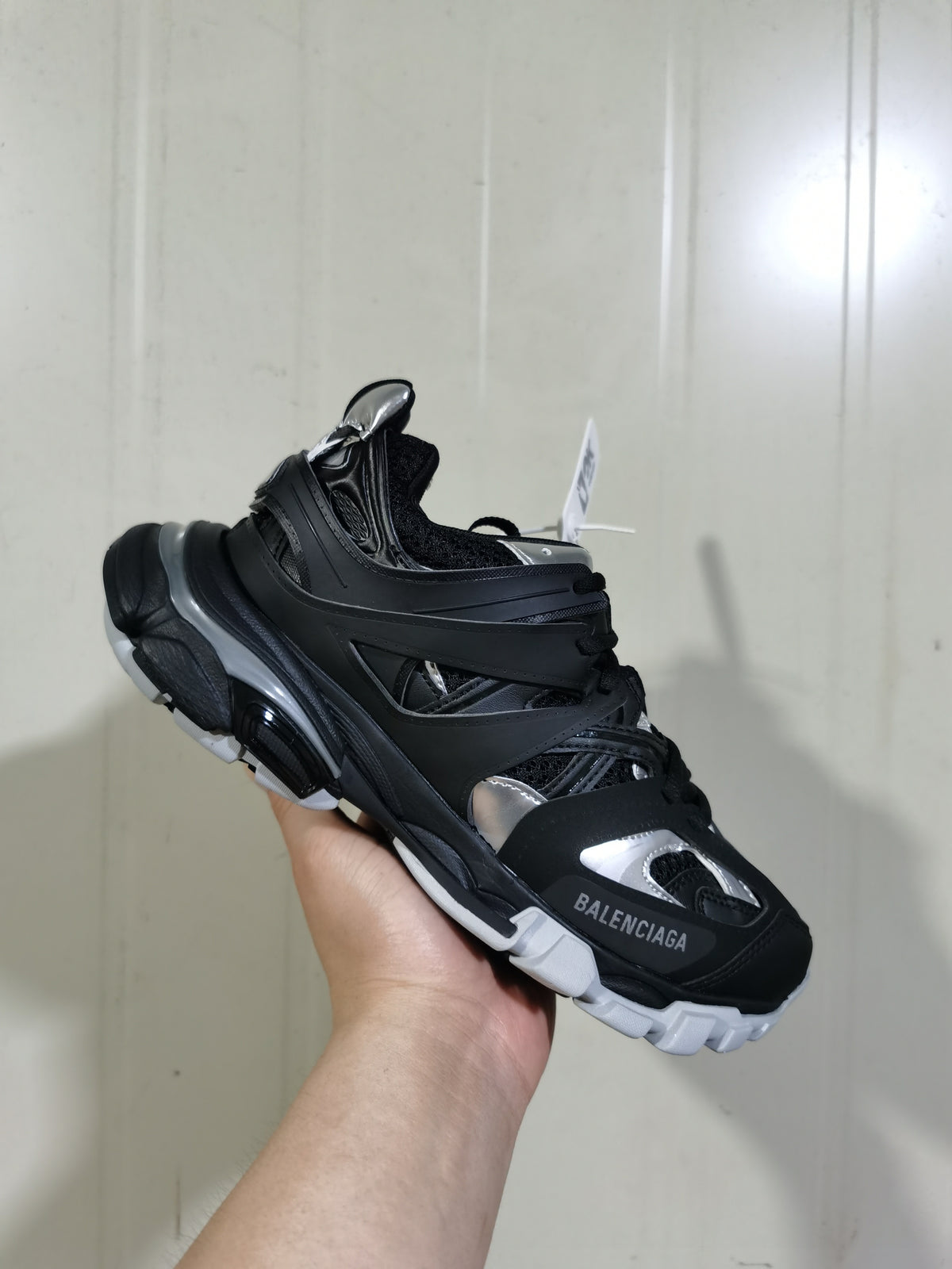 Close angled view of the black and silver Balenciaga sneaker showing the toe branding, layered upper, and chunky sculpted sole.