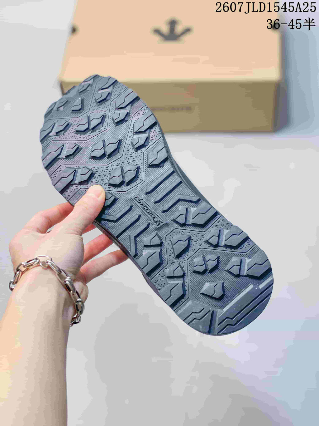 Close view of the black sneaker outsole showing a deep multidirectional lug pattern.