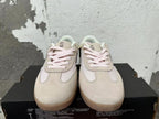 Front view showing pale pink laces and cream panels on Converse trainer-style sneakers