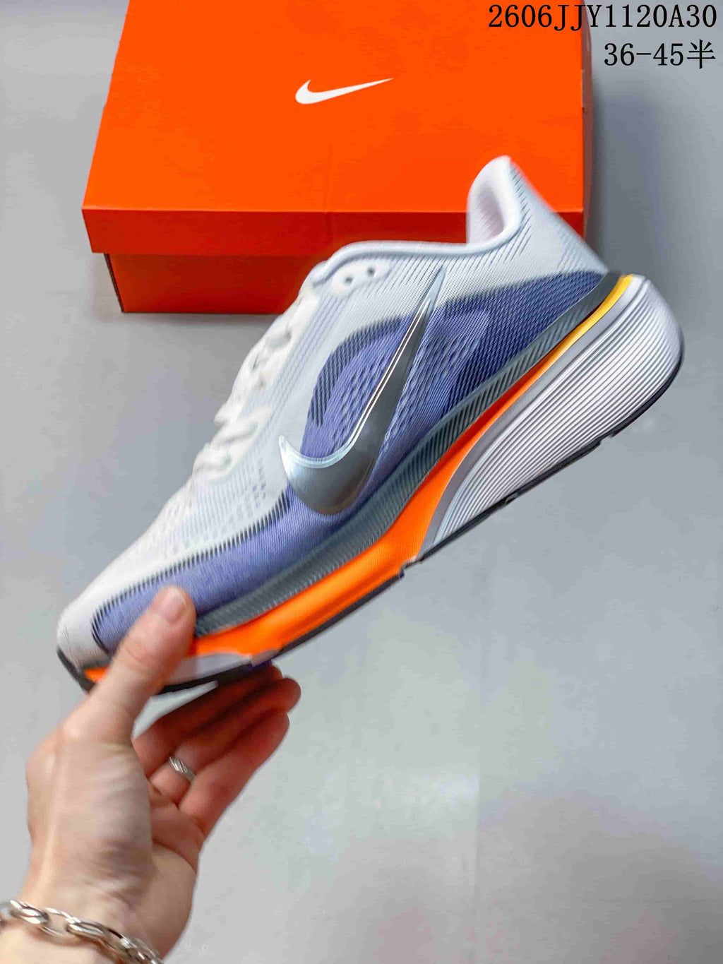 Side profile of a white and light purple Nike Pegasus 42 running shoe with orange midsole accents.