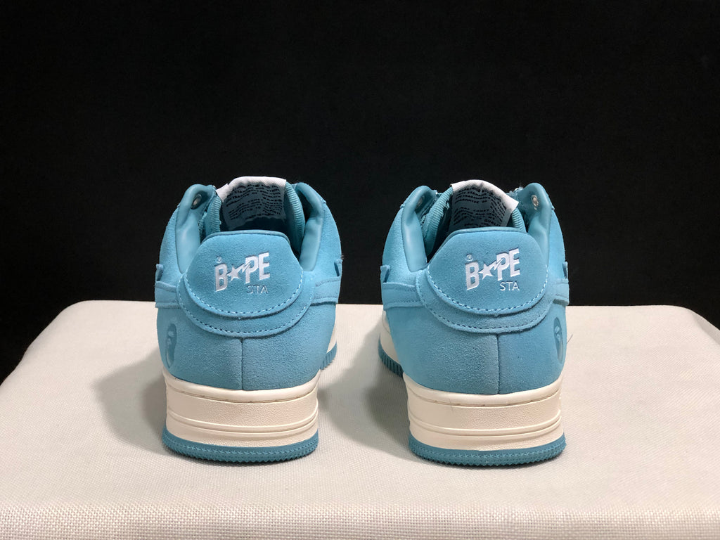 Rear view of the pair showing BAPE STA branding on the heel tabs and blue-and-off-white sole construction.