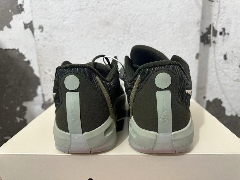Rear view of black and gray low-top basketball shoes with light-colored heel details