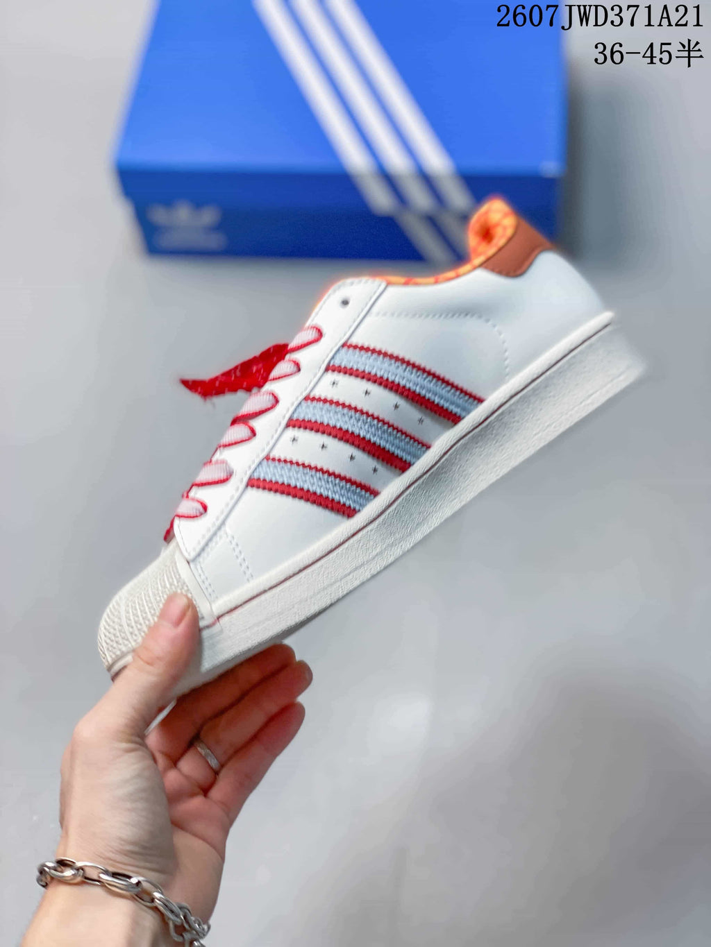 Side view showing the white upper, layered red and light blue stripes, star details, and white sole.