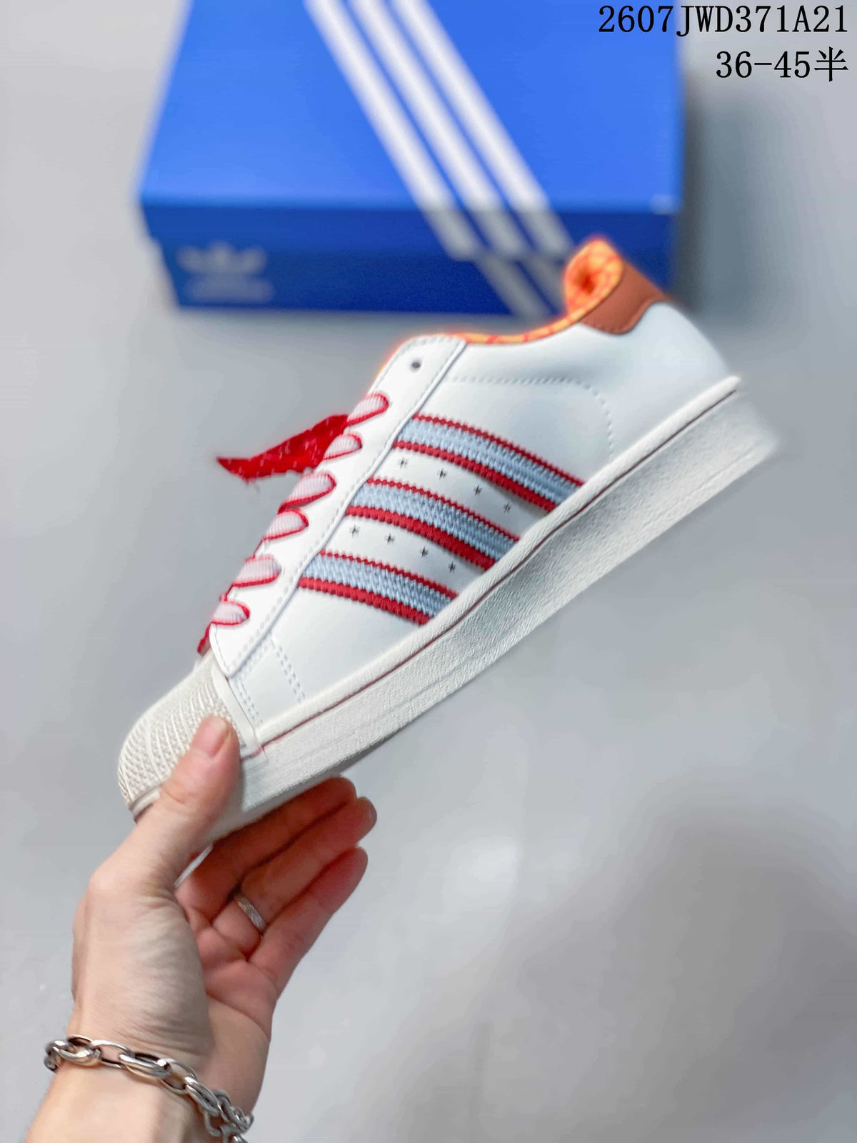 Side view showing the white upper, layered red and light blue stripes, star details, and white sole.