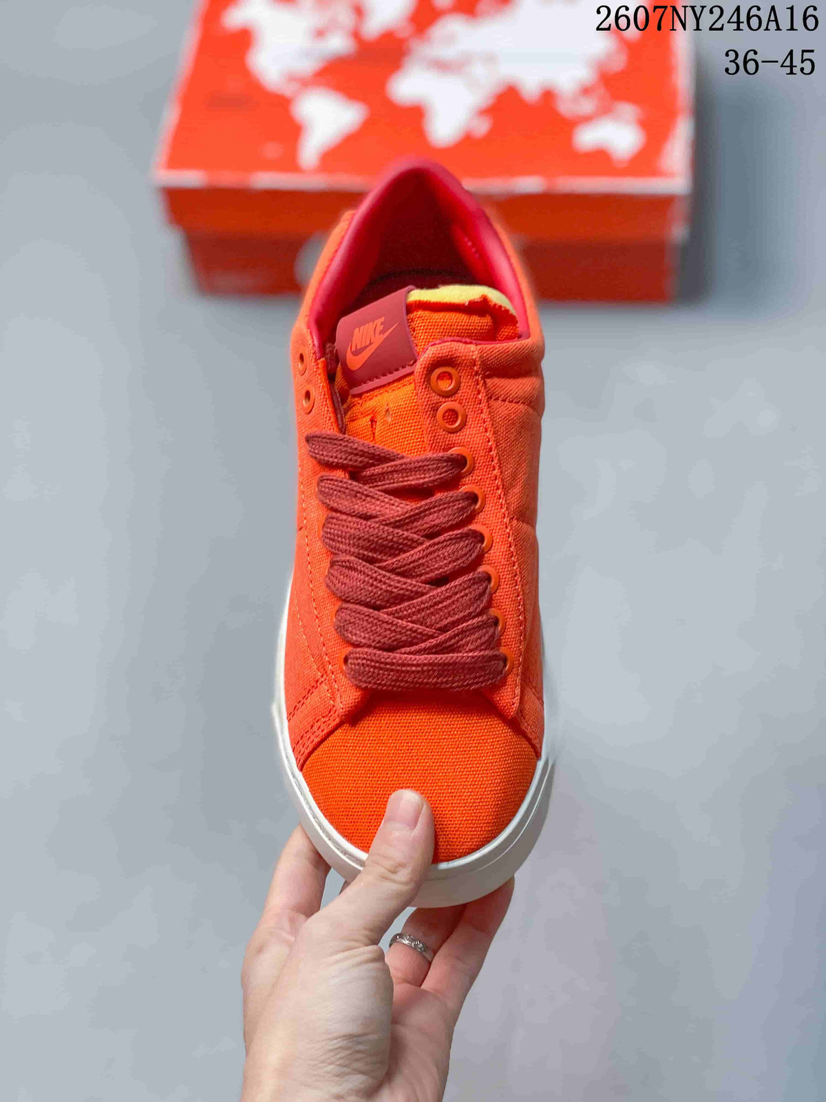 Top view of the orange sneaker showing the tongue branding, dark red laces, and padded collar.